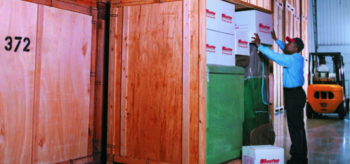 A man placing boxes in a wooden create showcasing the ability to store items for long term