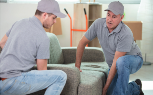 Two Olympia commercial movers in grey shirts working on a couch during a residential or commercial move.