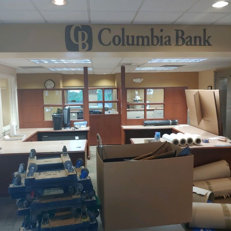 A Columbia Bank office undergoing commercial moving, filled with moving boxes and office furniture during a facility relocation.