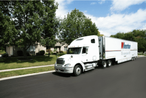 A massive moving semi truck cruising on the road, representing Olympic Movers' expertise in interstate and long distance moving.