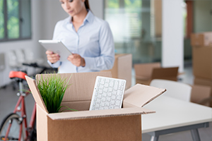 A woman stands before a box with a computer keyboard, representing an office moving service by a Tacoma moving company.