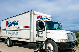 A white, Tacoma moving company moving truck with the words "Wheaton Moving" on the side, offering long-distance moving services in Tacoma.