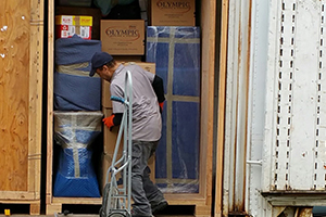 A Tacoma mover pushing a moving box into a storage container, representing project management for the Tacoma moving company.