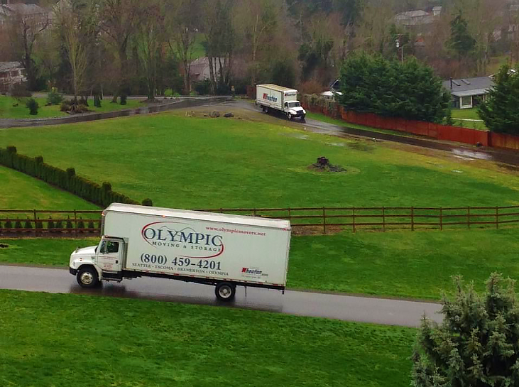 Washington's top moving company, Olympic Moving & Storage's truck driving up a residential road.