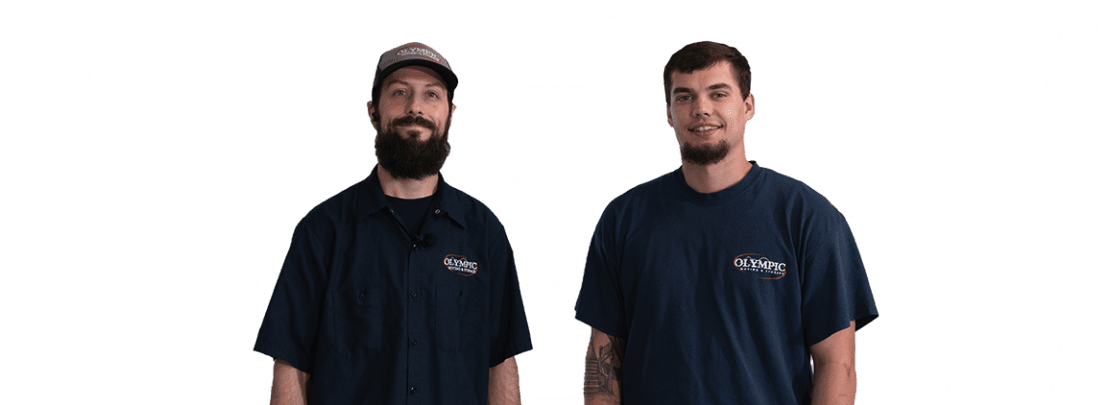 Two professional Washington movers in blue Olympic Moving and Storage shirts standing side by side.